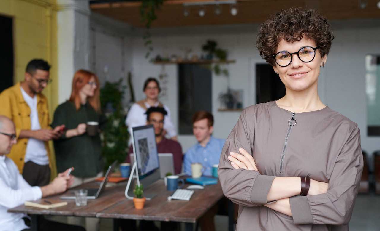 A human resources manager looks into the camera with satisfaction after helping to implement a whistleblower system.